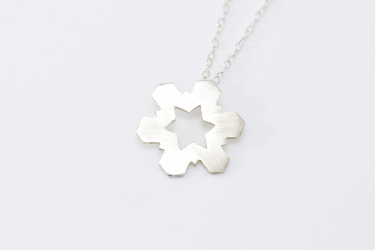 Silver necklace with a Snowflake-shaped pendant on a white background