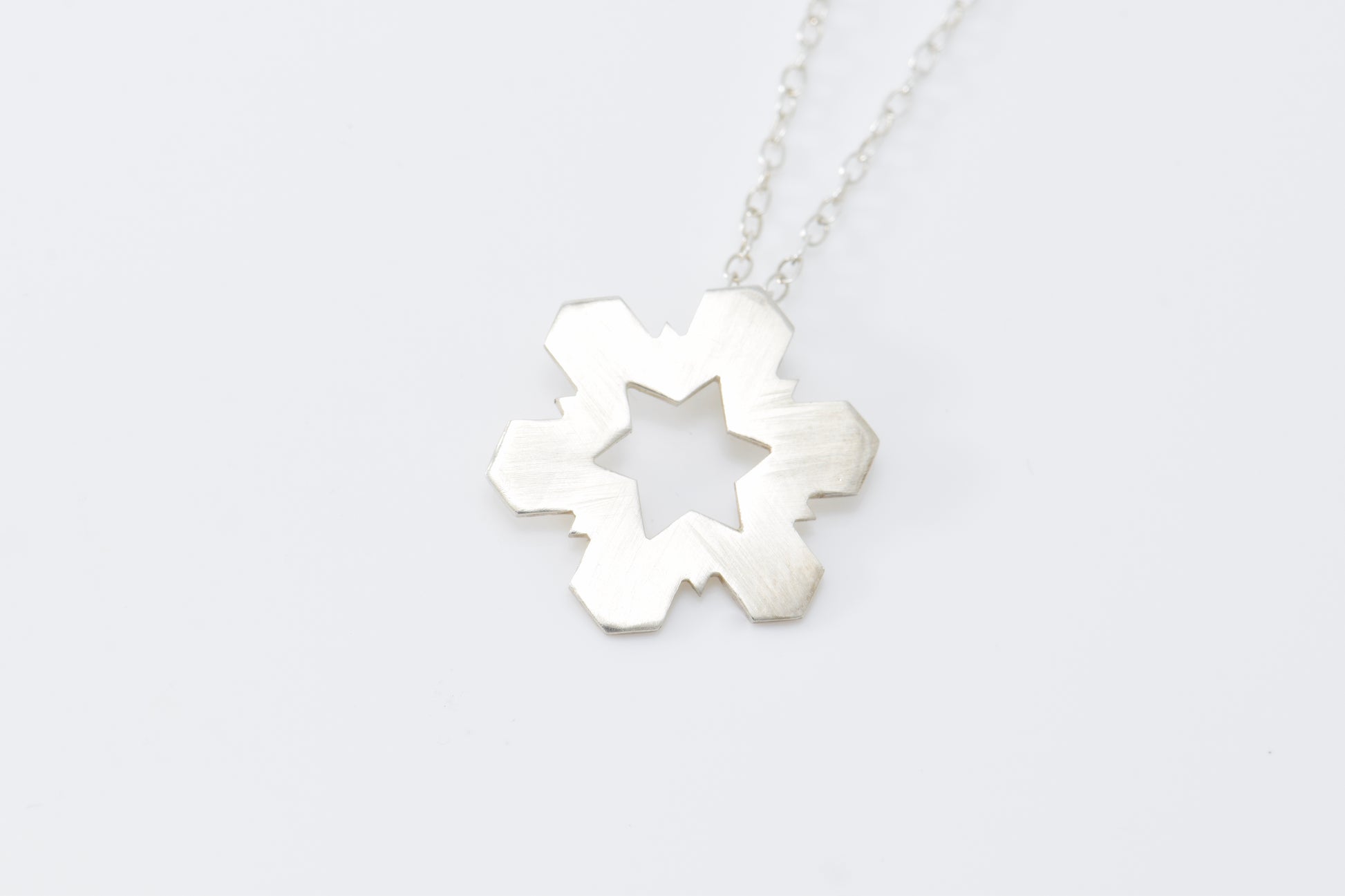 Silver necklace with a Snowflake-shaped pendant on a white background