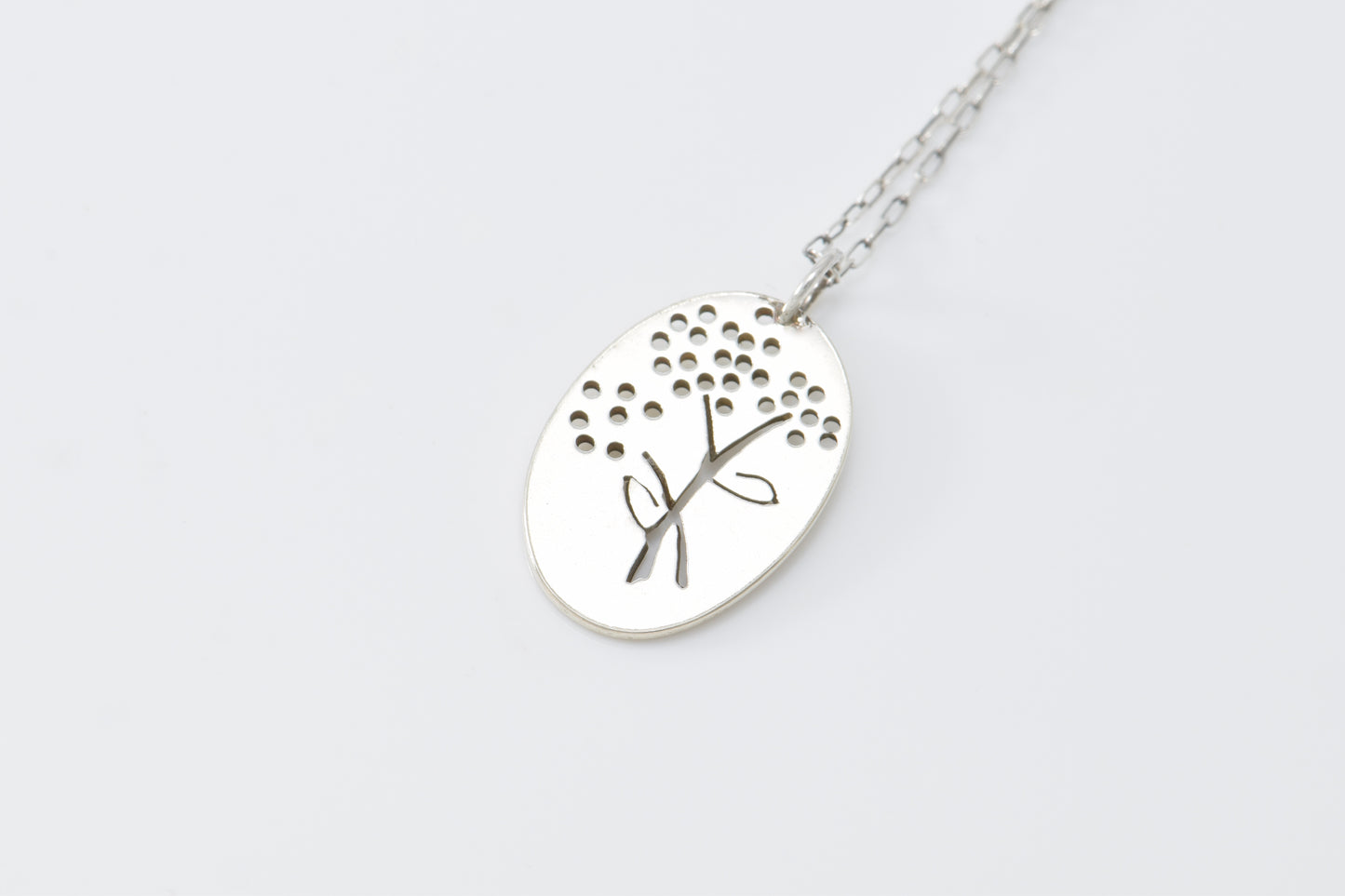 Silver necklace with a flower pendant on a white background