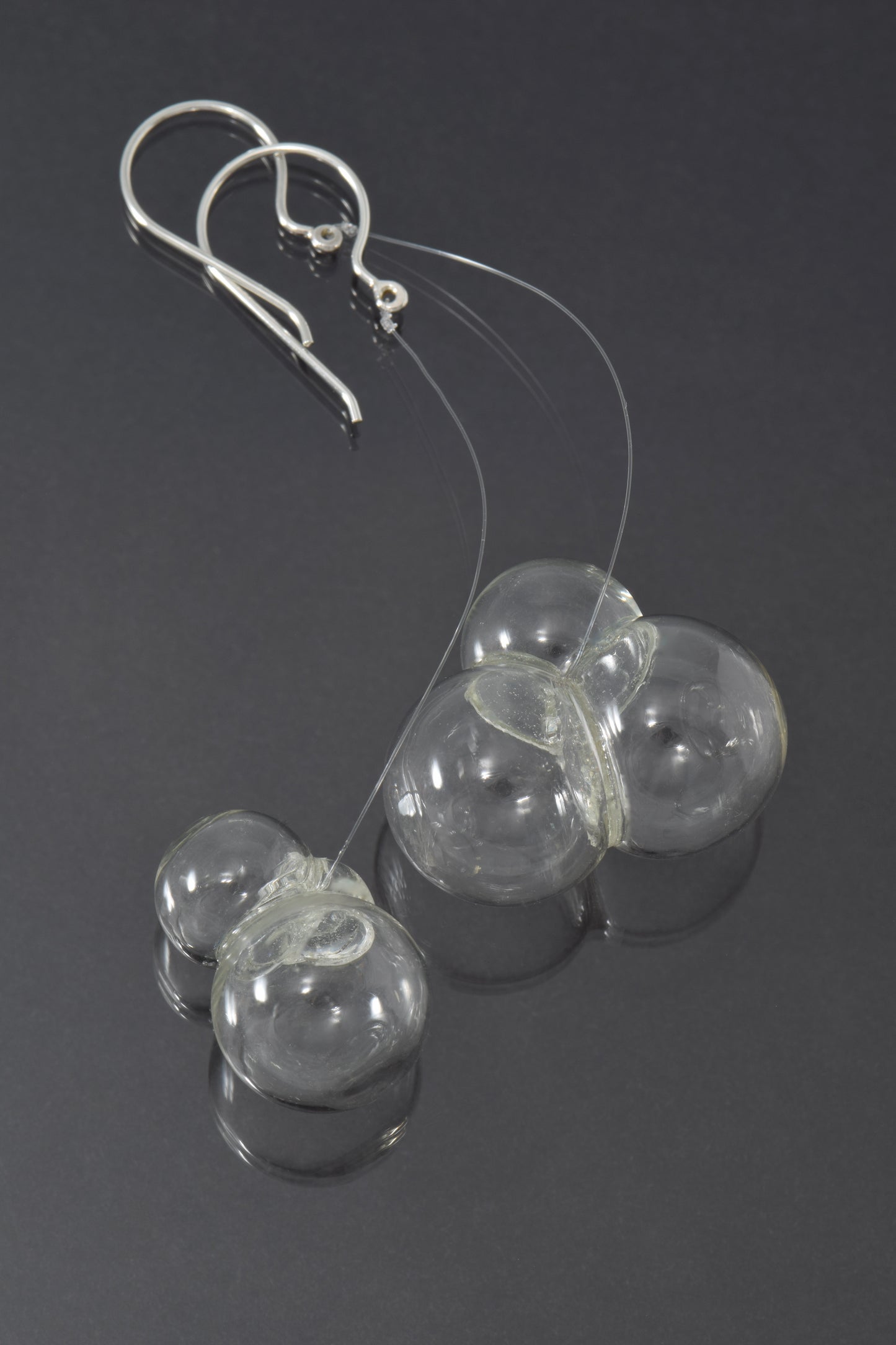 Triple glass bubbles hang on fluorocarbon below silver earwires.