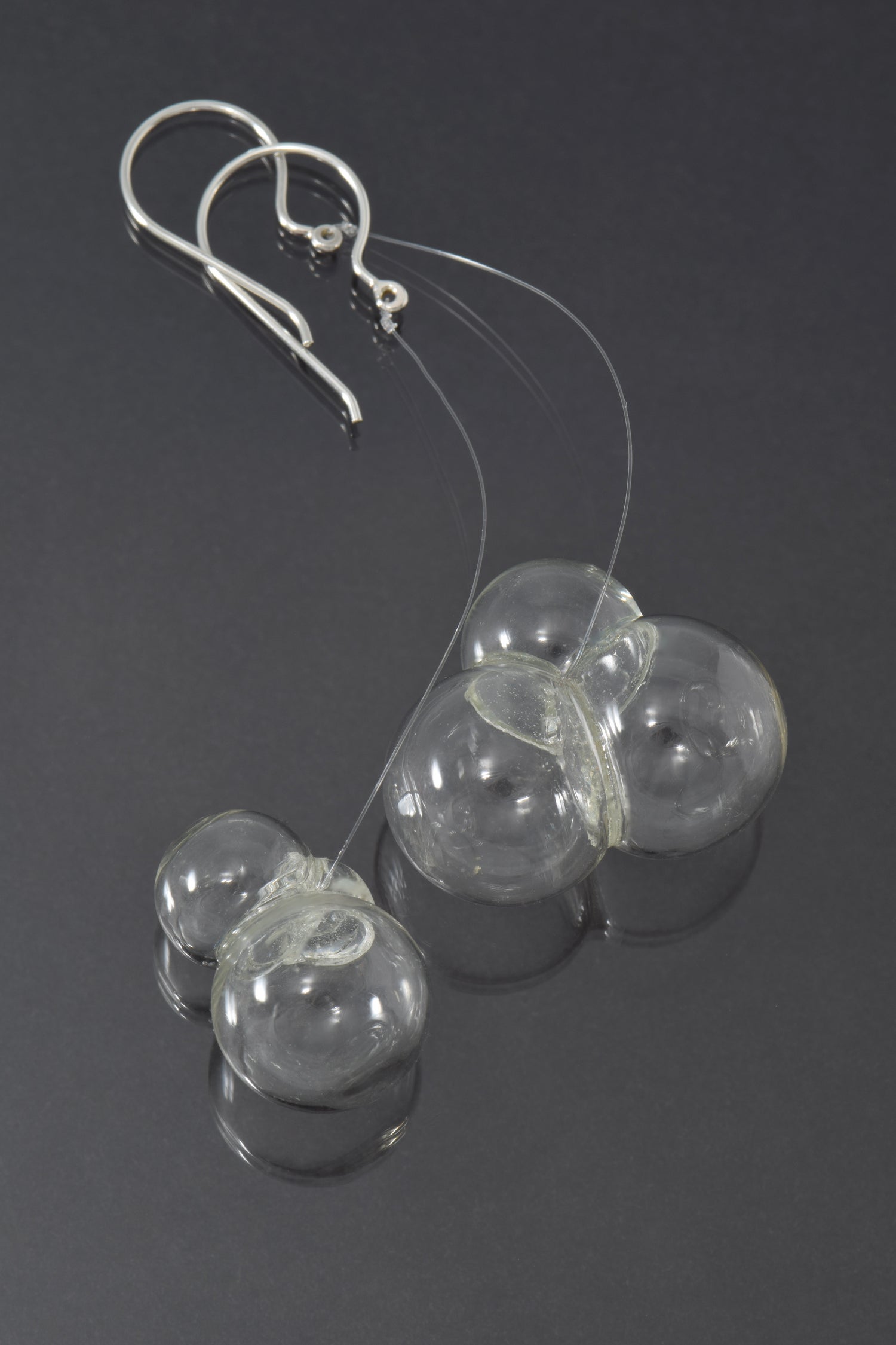 Triple glass bubbles hang on fluorocarbon below silver earwires.