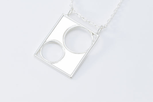 Silver necklace with a geometric pendant on a white background