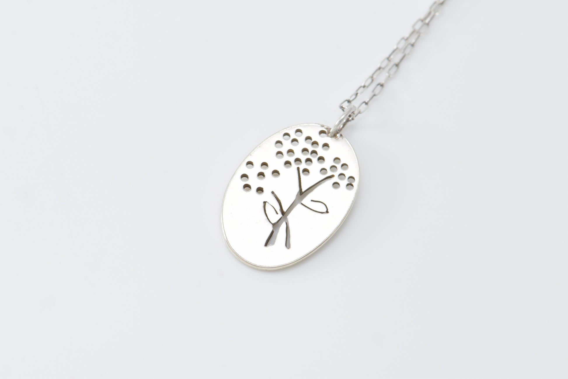 Silver necklace with a flower pendant on a white background