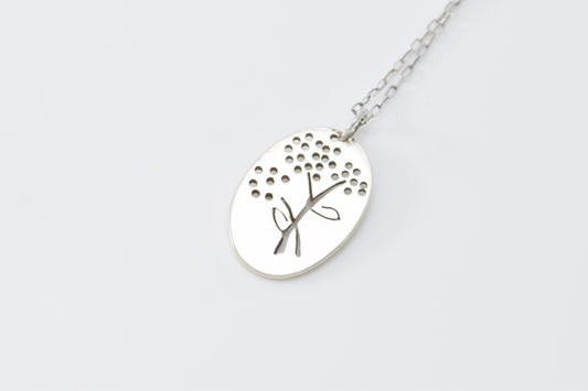 Silver necklace with a flower pendant on a white background
