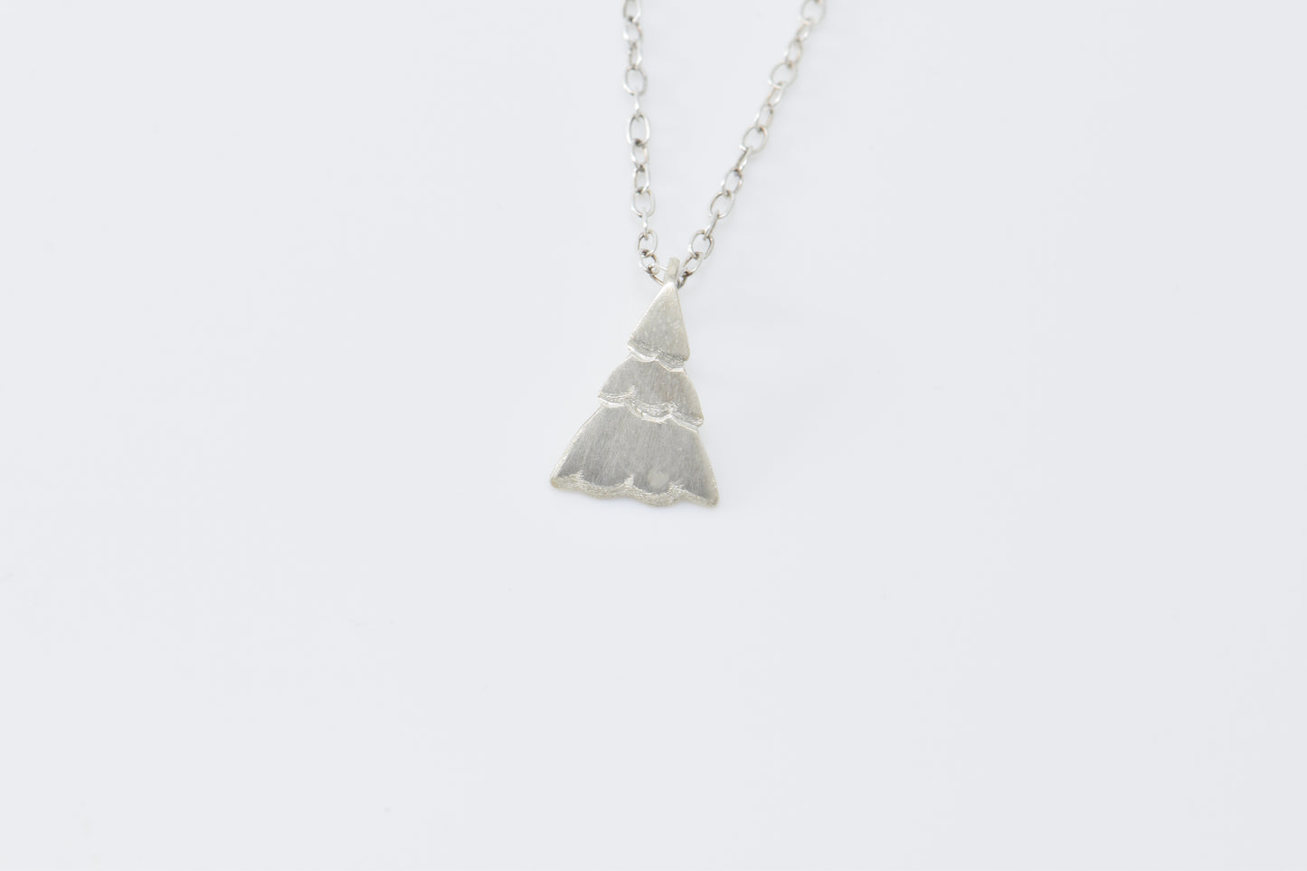 Small Christmas tree pendant on cable chain with white background
