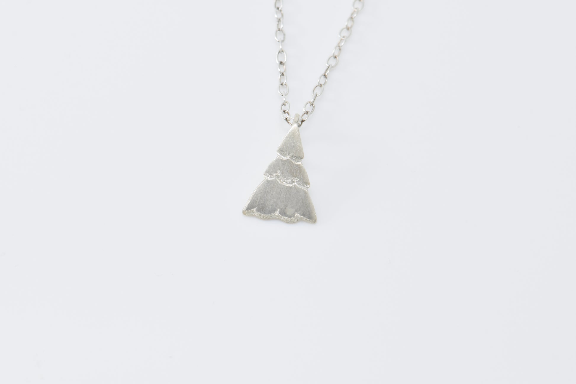 Small Christmas tree pendant on cable chain with white background