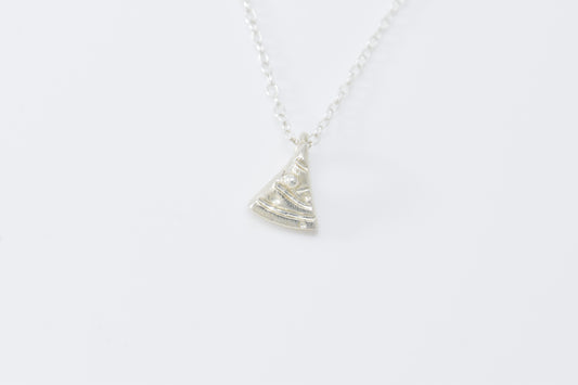 Tiny silver triangle Christmas tree with carved garland and ball ornaments on able chain.