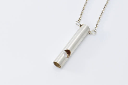 Silver whistle looking necklace on a white background