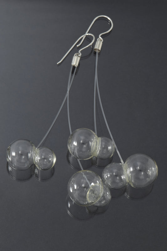 two pairs of bubbles at different lengths  on each earring on dark background